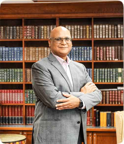 Portrait of Augustin James infront of bookshelf
